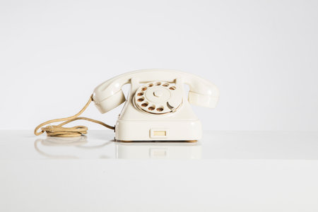 Old white telephone on a white background with reflection and copyspaceの写真素材