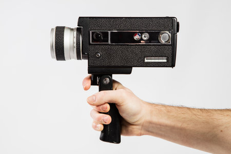 Man's hand holding an old camera on a white background, close-upの写真素材