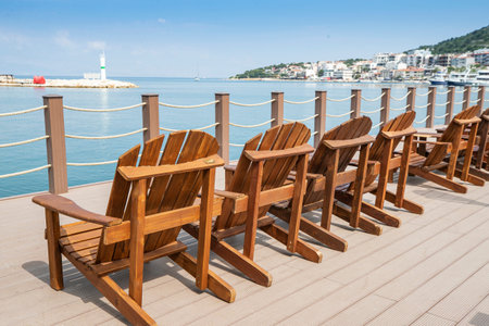 Wooden deck chairs on the pier by the sea. Montenegro