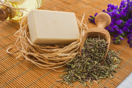 Herbal soap and lavender flowers on a bamboo mat background.の写真素材