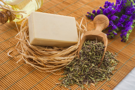 Herbal soap with dried herbs and olive oil on a bamboo matの写真素材