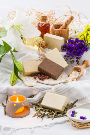Spa still life with natural soap, candles and flowers on white backgroundの写真素材