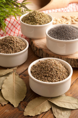 Assortment of spices in white bowls on wooden table, closeupの写真素材