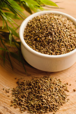 Dried oregano in a white bowl on a wooden backgroundの写真素材