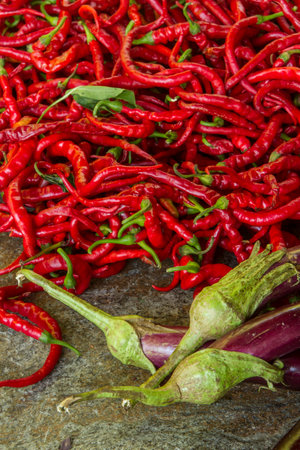 Red hot chili peppers and eggplant on stone background. top viewの写真素材