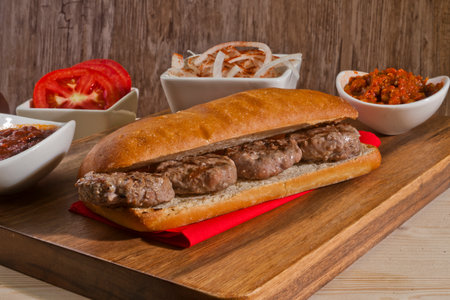 Appetizing hamburger on a wooden board with sauce and vegetablesの写真素材