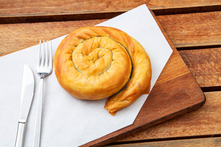 Bun with cheese and a fork on a wooden table in a restaurantの写真素材