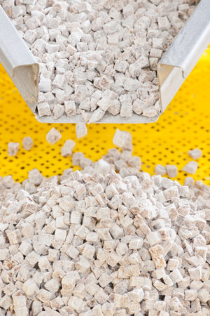 Pile of granulated cane sugar on a yellow plastic table.の写真素材