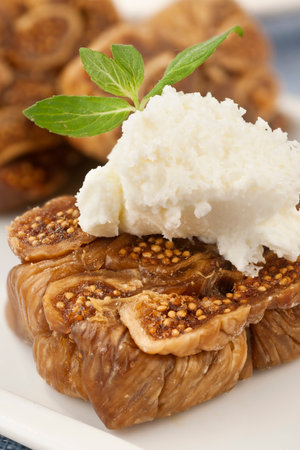 Sweet figs with cottage cheese on a white plate close-upの写真素材