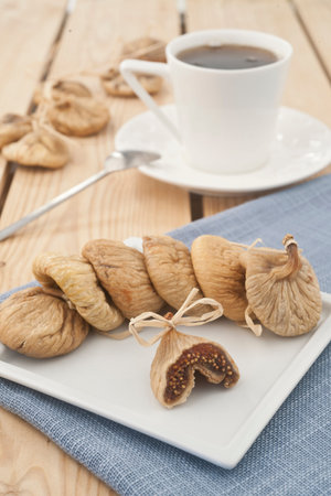 dried figs and a cup of coffee on a wooden table