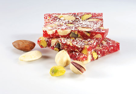 Turkish delight with pistachios and nuts on a white background.の写真素材