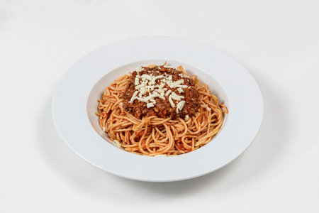 Spaghetti bolognese with parmesan cheese on white plateの写真素材