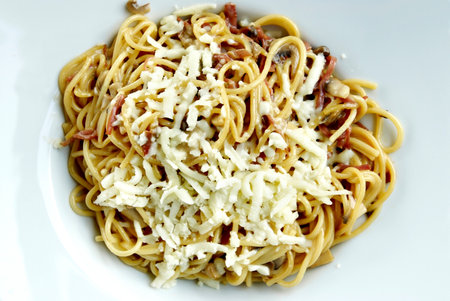 Spaghetti carbonara with bacon and parmesan on white plateの写真素材