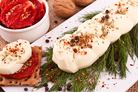 Slices of mozzarella cheese with herbs and spices.の写真素材