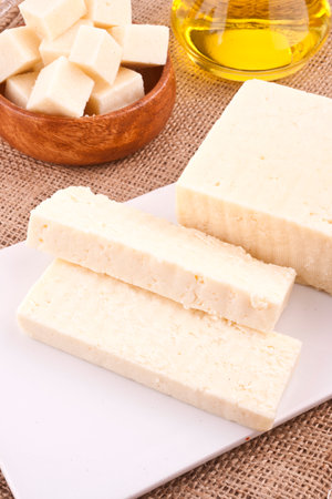 Natural soaps on a white cutting board with olive oil in the backgroundの写真素材