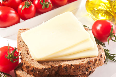 Slices of cheese on bread with tomatoes and olive oil.の写真素材