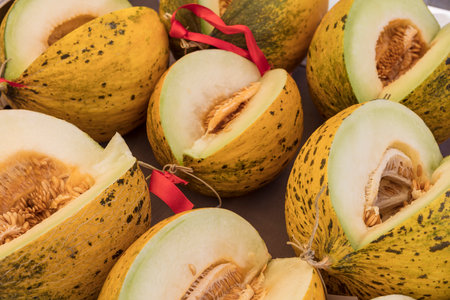 Ripe melons with a red ribbon on a wooden background.の写真素材