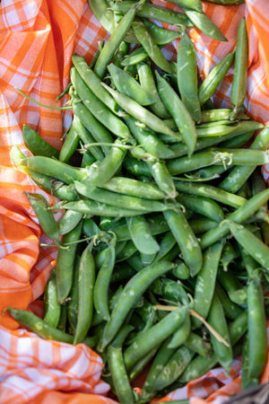 Fresh green peas in a basket at the farmers market. Selective focus.の写真素材