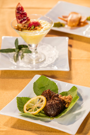 Fried figs with lemon and cream sauce on a white plateの写真素材