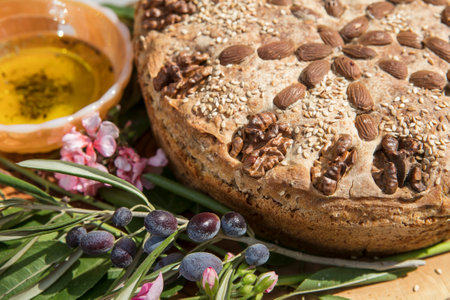 olive oil and bread with nuts and flowers on a wooden boardの写真素材