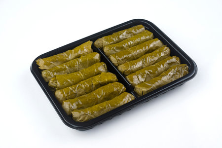 Stuffed grape leaves in a plastic container isolated on white background.の写真素材