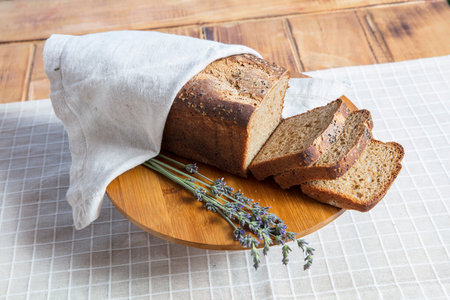 loaf of bread and lavender on a wooden plate on a table