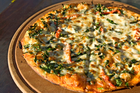Pizza with salmon and spinach on a wooden board, close-upの写真素材