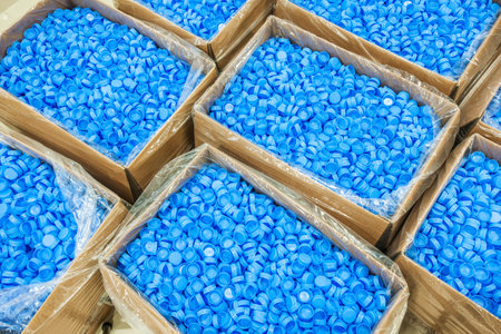 Blue plastic pellets in boxes on a shelf in a factory, closeup of photo