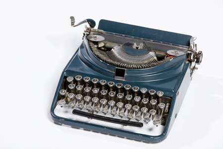 Old fashioned, vintage typewriter isolated on white background with a blank sheet of paper inserted with space for a custom messageの写真素材