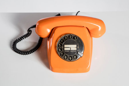 Orange telephone on a white background. Close-up, isolated.の写真素材