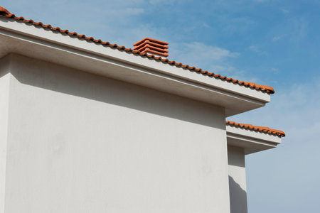 Roof of a modern house with red tile roof and blue sky