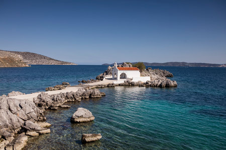 Little church of Agios Isidoros in the sea over the rocks, Chios island, Greece.の写真素材