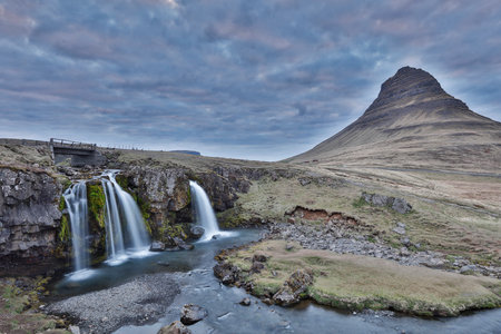 Kirkjufell is a free standing mountain of the Snaefellsnes peninsula, on the northern coast of Iceland. Together seen with the mountain, is a waterfall called Kirkjufellsfoss that flows into the sea.の写真素材