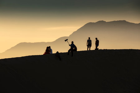 Silhouette of a group of people at the top of the sand duneの写真素材