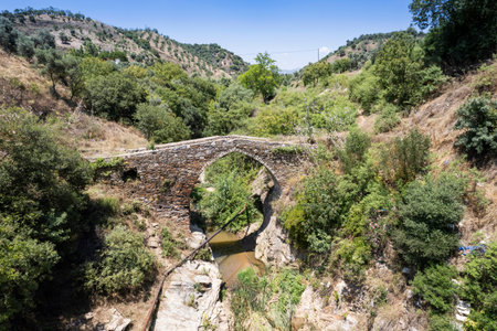 Old stone bridge over the small river in the mountains of Cyprus.