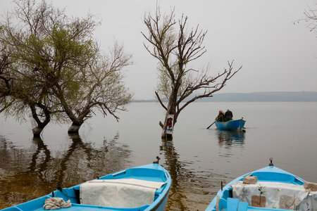 Fishermen are fishing on the lake in the early morning.の写真素材