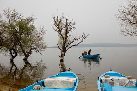 Fishermen are fishing in a small boat on the lake.の写真素材