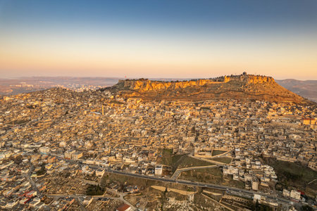 Traditional pink stone houses of Mardin Old town Mesopotamia in the background- Mardin, Turkey