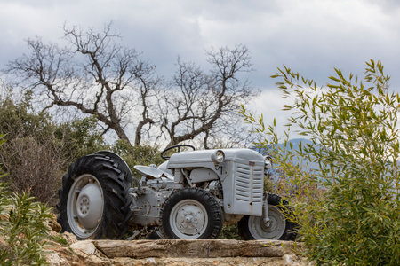 Old tractor stands on the stone against the background of the mountains.の写真素材
