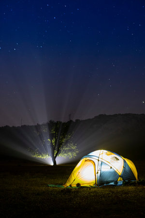 Camping on the mountain at night with starry sky background.の写真素材