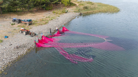 Coastal fishing.Fisherman taking the net in the Lake Iznik. Aerial view of the historical city of...