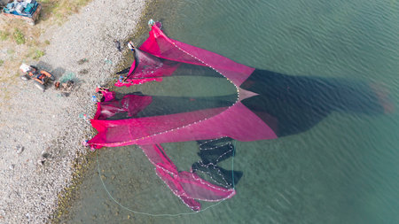 Coastal fishing.Fisherman taking the net in the Lake Iznik. Aerial view of the historical city of Iznik by the Iznik Lake, Turkey.の写真素材