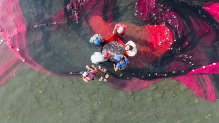 Coastal fishing.Fisherman taking the net in the Lake Iznik. Aerial view of the historical city of...