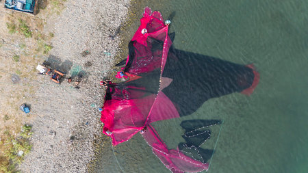 Coastal fishing.Fisherman taking the net in the Lake Iznik. Aerial view of the historical city of Iznik by the Iznik Lake, Turkey.の写真素材