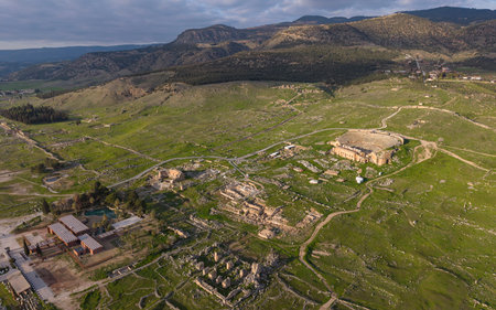 Aerial drone view of Hierapolis Ancient City and the famous Pamukkale travertines in Denizli, Turkey, showing ancient ruins, Roman theater, columns, and scenic landscape from above.の写真素材