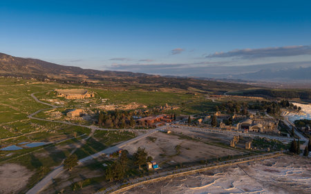 Aerial drone view of Hierapolis Ancient City and the famous Pamukkale travertines in Denizli, Turkey, showing ancient ruins, Roman theater, columns, and scenic landscape from above.の写真素材