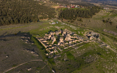 Aerial drone view of Hierapolis Ancient City and the famous Pamukkale travertines in Denizli, Turkey, showing ancient ruins, Roman theater, columns, and scenic landscape from above.の写真素材