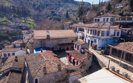 Aerial drone view of Åirince KÃ¶yÃ¼ in Izmir, Turkey, showcasing traditional stone and wooden houses, narrow streets, vineyards, and the scenic hillside landscape from above.の写真素材