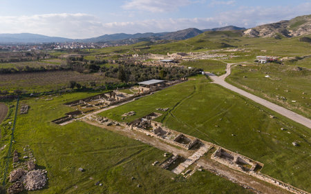Aerial drone view of Tripolis Ancient City near Buldan in Denizli, Turkey, showing ancient Roman ruins, stone structures, columns, and scenic hillside landscape from above.の写真素材