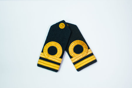 A pair of epaulette gold bar second officers, isolated on white overlapping top down view
